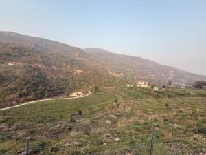 a field with a fence and a road on a hill at The Dungi Ser Experience in Sīyūn