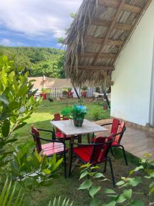 a table and chairs under a wooden roof at Dreamvilles Ecovillage Bed and Breakfast near Playa Aserradero in Las Galeras