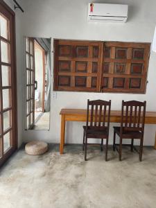 a dining room with a wooden table and two chairs at Pousada Spa Oasis in Caraíva
