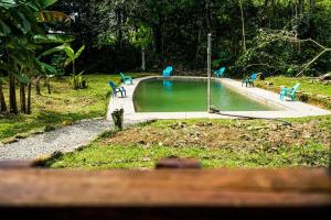 a swimming pool with blue chairs in a park at Casa de Astilla in Mocoa