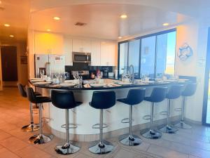 a kitchen with a large counter with stools and a bar at Las Palomas OV 4BR 4BA Cortez 901 in Puerto Peñasco