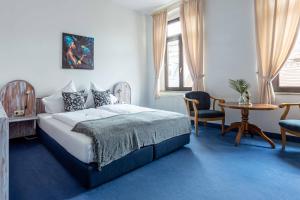 a bedroom with a bed and a table and chairs at Hotel Mauritius - Im Herzen von Crimmitschau - Frühstück buchbar - Fahrradbox in Crimmitschau