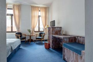 a hotel room with two beds and a table and chairs at Hotel Mauritius - Im Herzen von Crimmitschau - Frühstück buchbar - Fahrradbox in Crimmitschau