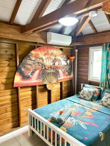 a bedroom with a bed in a wooden cabin at Gwada fun habitation in Saint-Claude