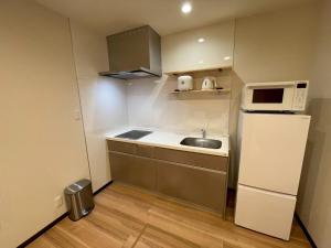a small kitchen with a sink and a refrigerator at Casa Kokoro Hakuba in Hakuba +8 photos