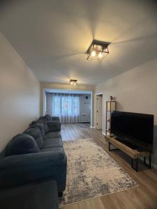 a living room with a couch and a flat screen tv at Friendship Residence in Thunder Bay