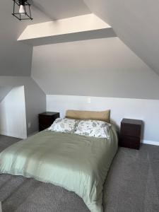 a bed in a room with a white wall at Friendship Residence in Thunder Bay