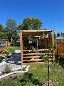 a wooden gazebo with a swing in a yard at Friendship Residence in Thunder Bay