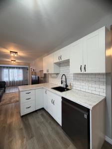 a kitchen with white cabinets and a sink at Friendship Residence in Thunder Bay