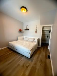 a bedroom with a bed in a white room at Friendship Residence in Thunder Bay