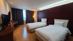 a hotel room with two beds and a television at Sun Valley Hotel in Yeoju
