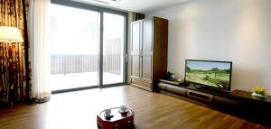 a living room with a television and a large window at Sun Valley Hotel in Yeoju