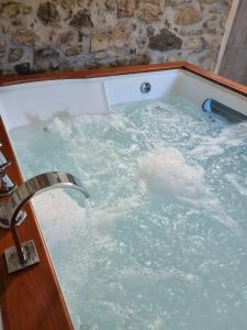 a jacuzzi tub with water coming out of it at "Rosa di sera" - Relax in Toscana con Spa privata in Tresana