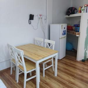 a kitchen with a table and chairs and a refrigerator at La Palmera Apartment in San Bartolo