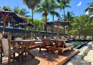a resort patio with tables and chairs and a swimming pool at Amaite Holbox - Oceanfront Hotel in Holbox Island