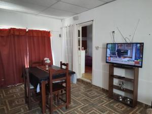 a living room with a table and a television at Lo de Norma in Neuquén