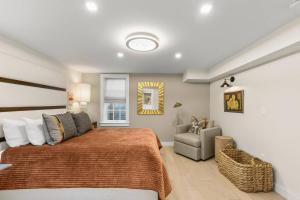 a bedroom with a large bed and a chair at Modern Design - Walk to Galleries + Beach + Dining in Provincetown