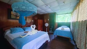 a bedroom with a bed with two stuffed animals on it at Jacamar Lodge Expeditions in Iquitos +82 photos