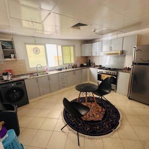 a kitchen with a table and two chairs in it at Bedroom separately in Sharjah