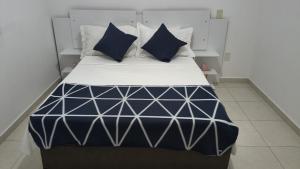 a bed with blue and white sheets and pillows at Apto mobiliado no edificio saveiro com garagem in São José dos Campos