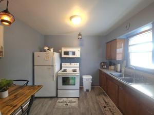 a kitchen with a white refrigerator and a microwave at Stay St Paul Haven in West Saint Paul