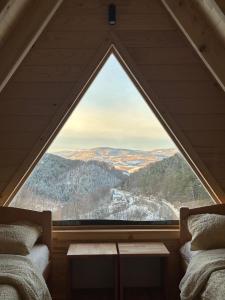 zwei Betten in einem Zimmer mit großem Fenster in der Unterkunft Vikendice Kovacevic in Tugovo