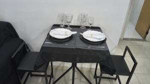 a black table with glasses and plates and napkins at Apto mobiliado no edificio saveiro com garagem in São José dos Campos +9 photos