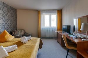 a hotel room with a bedroom with a desk and a bed at Nova Hotel in Radom