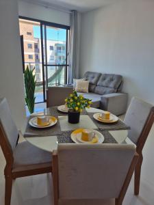 a dining room table and chairs with a table and a couch at Beira Mar Apartment Aracaju in Aracaju