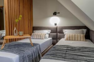 a room with two beds and a table in it at Apart-Hotel Bela Reka in Brzeće