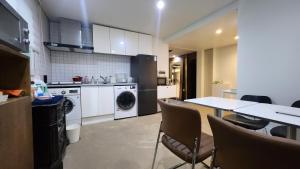 a kitchen with a table and a washing machine at Jin Stay Hotel in Changwon