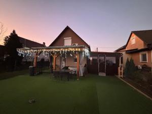 a backyard with a pergola with lights on it at Bíbic Vendégház in Kaposvár