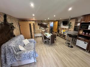 a living room with a couch and a kitchen at Bíbic Vendégház in Kaposvár