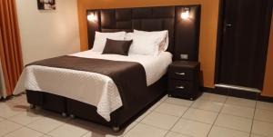 a bedroom with a large bed with white sheets and pillows at Hospedaje Tunari - Chalet de Lujo con Jacuzzy, Jardin, Horno y Barbacoa a Leña in Quillacollo