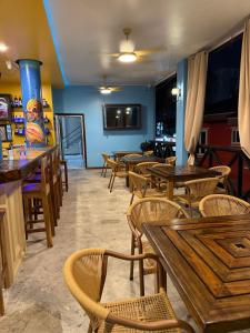 a restaurant with tables and chairs in a room at Hotel Royal Blue & Golf Cart Rental in San Pedro