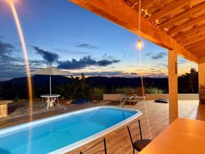 a villa with a swimming pool and a table at Chalés Sonho Meu in Munhoz