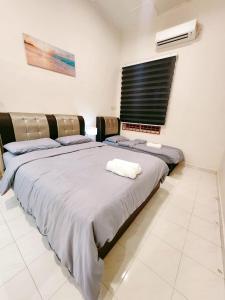a bedroom with two beds and a window in it at Mersing 746homestay-9pax in Mersing