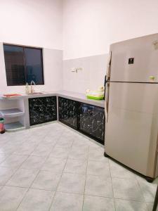 a kitchen with a white refrigerator and a sink at Mersing 746homestay-9pax in Mersing