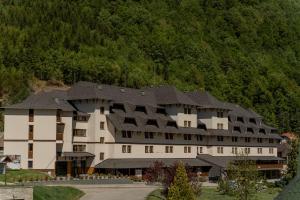 a large white building with a black roof at Apart-Hotel Bela Reka in Brzeće