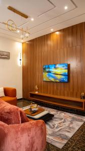a living room with a couch and a tv on a wall at Golden Appart in Godomey +1 photo