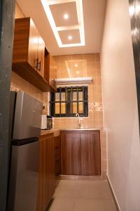 a kitchen with a sink and a refrigerator at Golden Appart in Godomey
