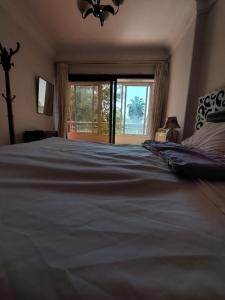 a large bed in a bedroom with a large window at Cozy Queen bed room in zamalek with garden view and balcony in Cairo +3 photos
