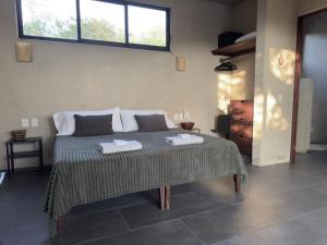 a bedroom with a bed with two towels on it at Quiet Oceanside Casita Private Kitchen & Bath in Troncones
