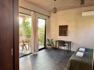 a room with a bed and a table and a window at Quiet Oceanside Casita Private Kitchen & Bath in Troncones