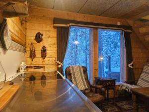 a living room with a glass table and a window at The Lakeview Cabin in Kiruna