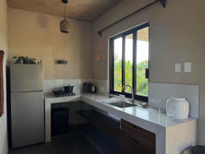 a kitchen with a sink and a refrigerator at Quiet Oceanside Casita Private Kitchen & Bath in Troncones +29 photos