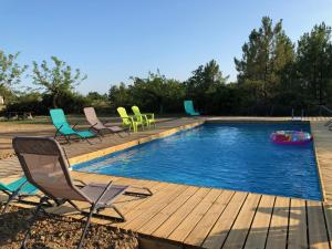 a pool with chairs and a raft in the middle at Hamlet de moment Ardeche com in Lablachère