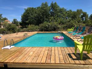 a swimming pool with chairs and a swimming poolvisor at Hamlet de moment Ardeche com in Lablachère