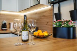 a table with two wine glasses and a bowl of oranges at NOVA SPA - Sauna Suite for Two in Rijeka +14 photos