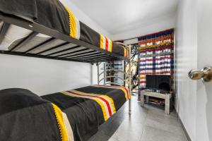 a bedroom with two bunk beds and a tv at Suites Calle Berlin in Mexico City